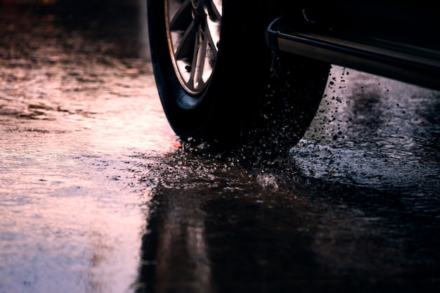 Movimiento de coche en lluvia gran charco con agua salpicando de las ruedas