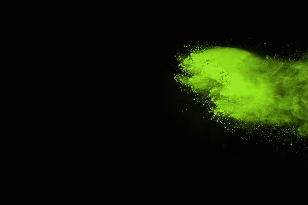 El movimiento de explosión de polvo abstracto congelado verde sobre fondo negro.