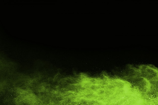 Foto el movimiento de explosión de polvo abstracto congelado verde sobre fondo negro.