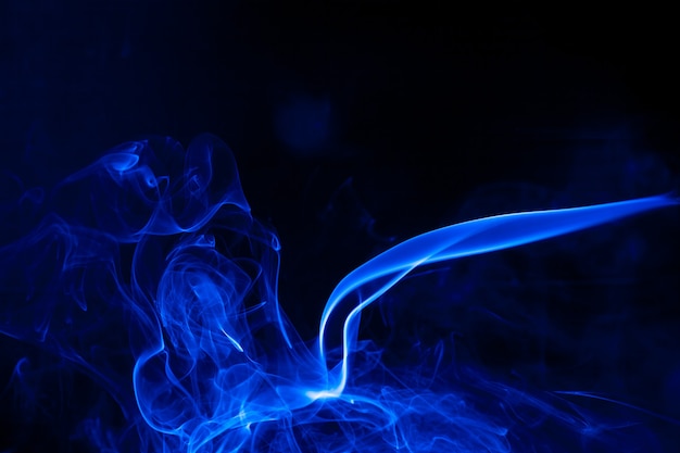 Movimiento de humo azul sobre fondo negro.