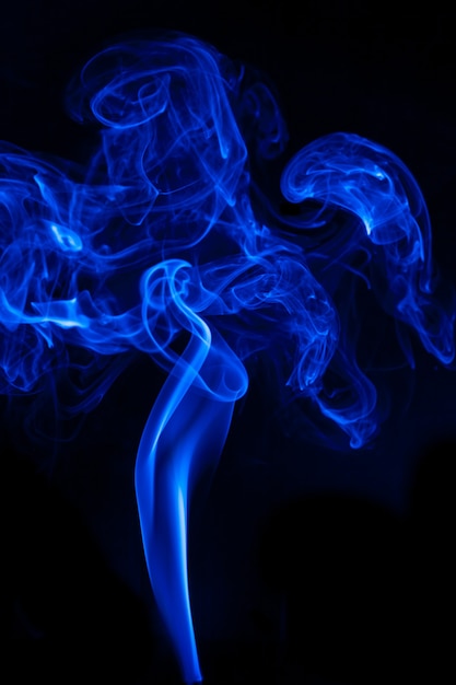 Movimiento de humo azul sobre fondo negro.