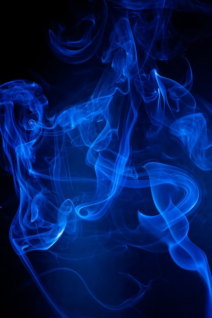 Movimiento de humo azul sobre fondo negro.