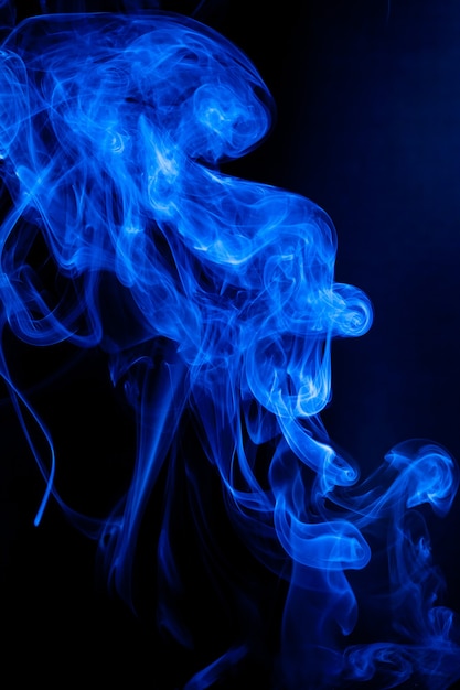 Movimiento de humo azul sobre fondo negro.