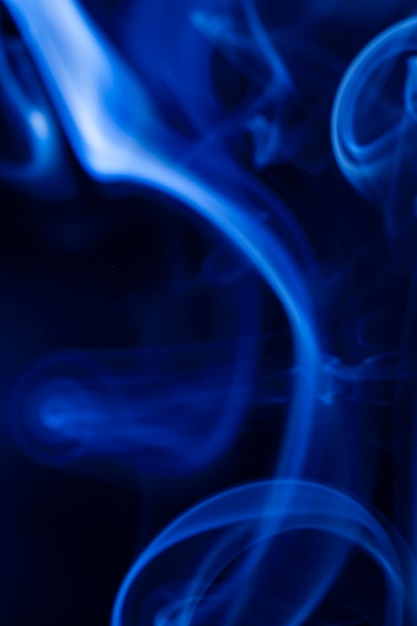 Movimiento humo azul sobre fondo negro.