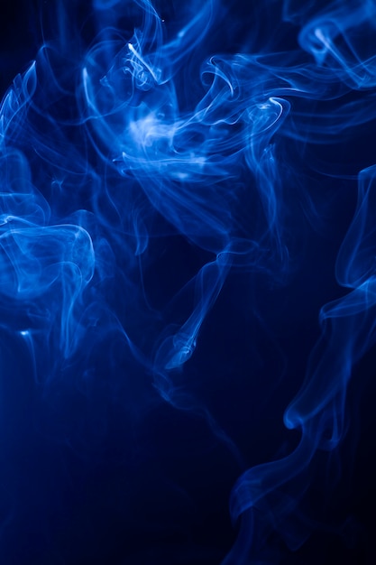 Movimiento humo azul sobre fondo negro.