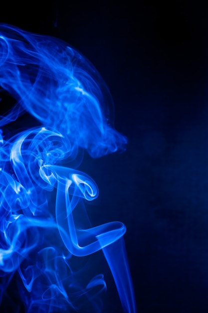 Foto movimiento de humo azul sobre negro.