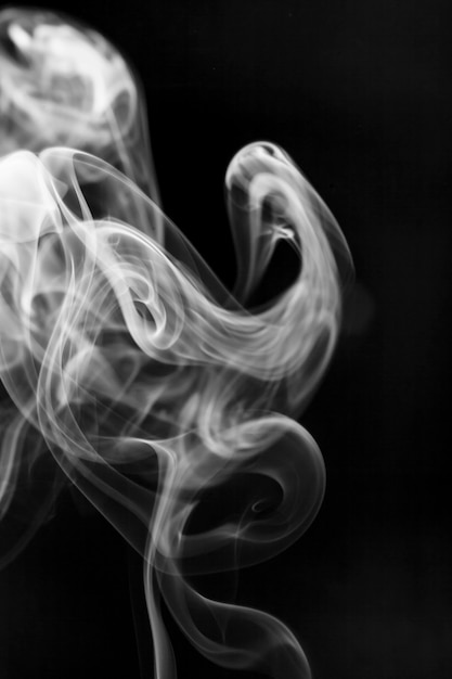 Movimiento de humo blanco sobre fondo negro.