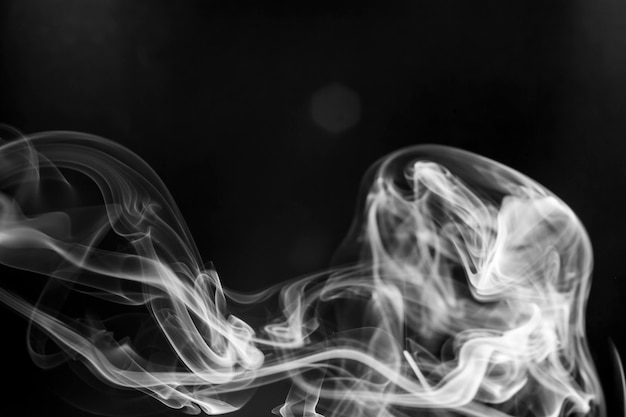 Movimiento de humo blanco sobre fondo negro.