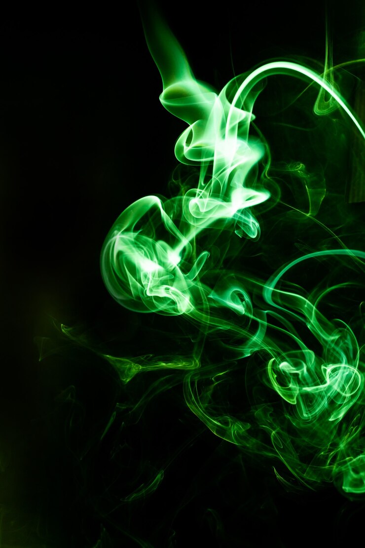 Movimiento de humo verde sobre fondo negro.