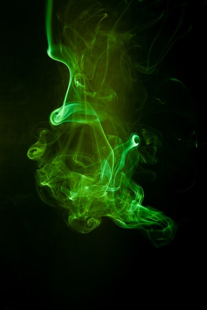 Movimiento de humo verde sobre fondo negro.