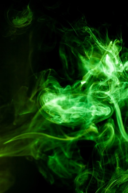 Foto movimiento de humo verde sobre negro.