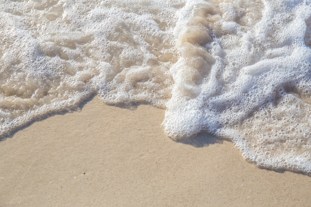 El movimiento de las olas en la arena es suave y fino para el fondo