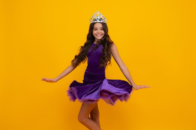 Movimiento ventoso vestido adolescente princesa niño celebra éxito ganar y victoria adolescente niña en reina corona feliz niña cara positiva y sonriente emociones