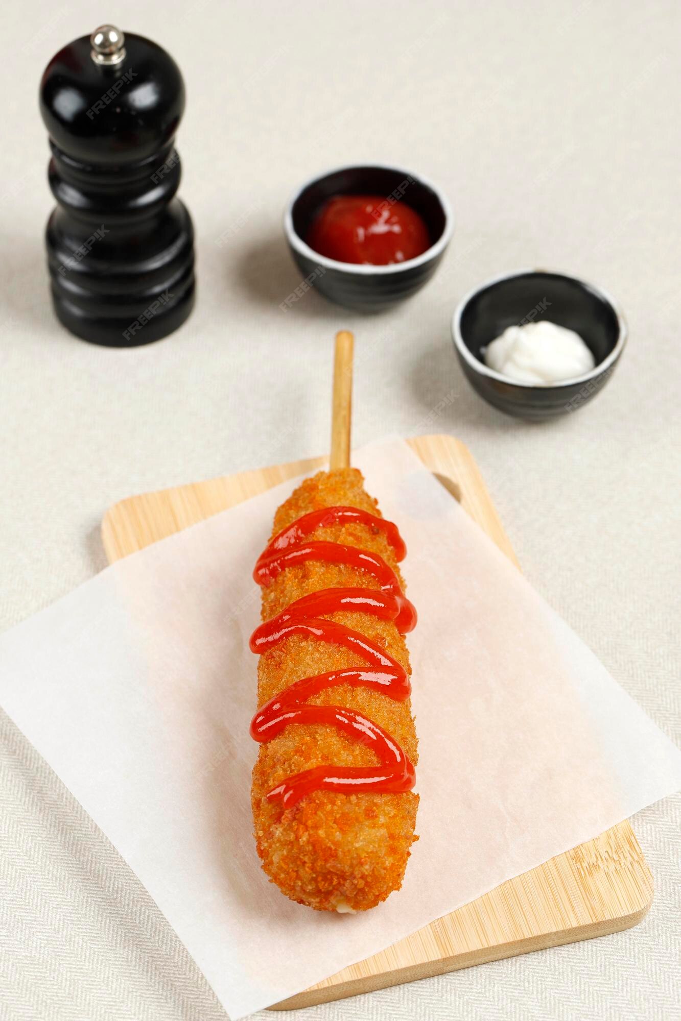 Corn dog é uma salsicha no palito com queijo mussarela, revestida com massa  de farinha e frita. comida de rua coreana de cachorro-quente