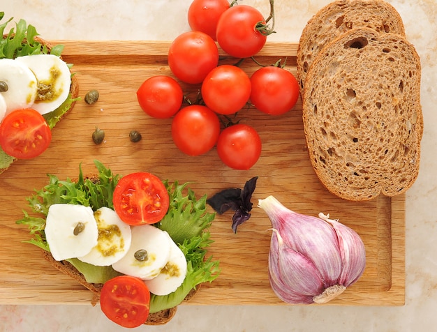 Mozarella con tomates en una tabla de madera