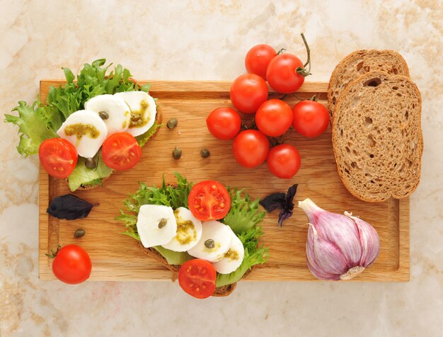 Mozarella con tomates en una tabla de madera