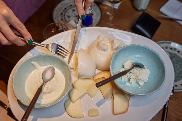 Mozzarella-Käse-Basilikum, Nahaufnahme, Draufsicht, weibliche Hände, die mit einem Messer schneiden