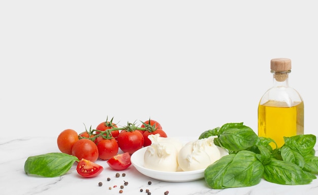 Mozzarella mit Tomatenbutter und Basilikum auf weißem Hintergrund