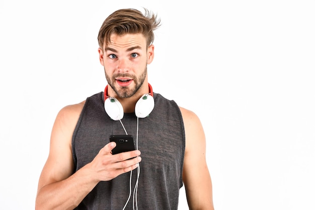 MP3-Player sexy muskulöser Mann hört Musik am Telefon MP3-Player Mann mit MP3-Player am Telefon isoliert auf weiß unrasierter Mann mit Kopfhörern Lieblingsmusik teilen
