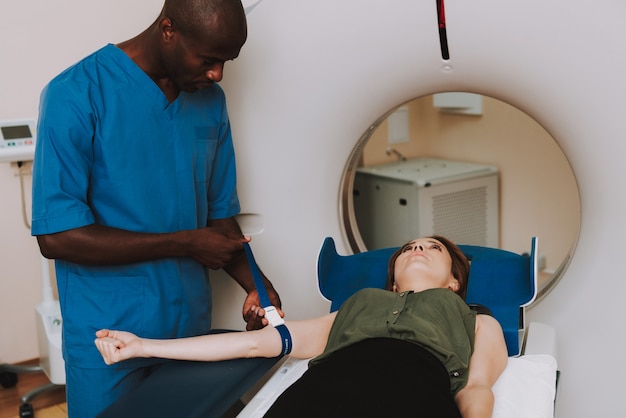 MRI Diagnostic Afro Doctor, der geduldige Hand repariert.