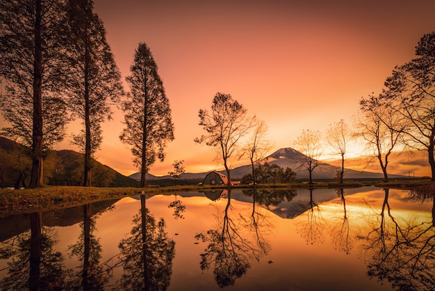 Mt. Fuji com grandes árvores e lago ao nascer do sol em Fujinomiya, Japão.