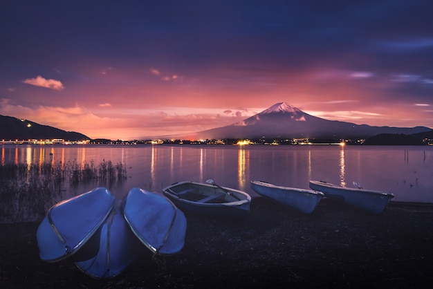 Mt. fuji sobre o lago kawaguchiko com os barcos no por do sol em fujikawaguchiko, japão.