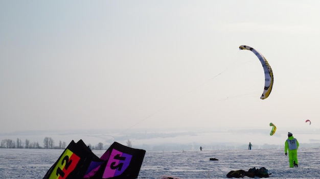 Mucha gente practica snowkite Paracaidismo en terreno nevado Tiendas de campaña de invierno