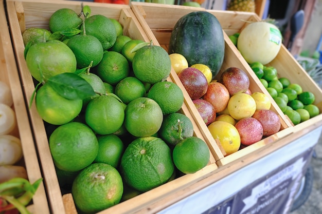 Mucha mandarina y muchas frutas mezcladas en una canasta de madera para el cabello.