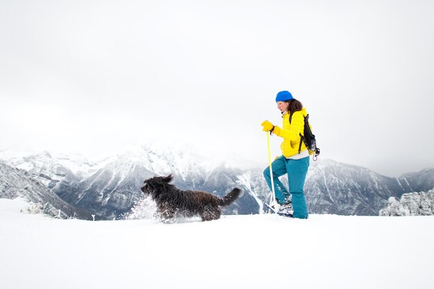 Mucha nieve durante una excursión con raquetas de nieve Una niña con su amado perro