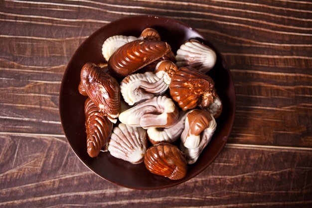 Mucha variedad de bombones de chocolate en un plato. Vista superior.