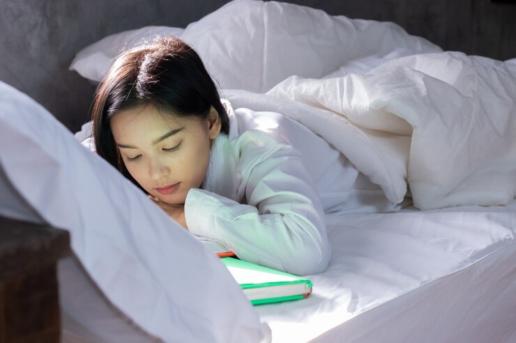 Muchacha adolescente asiática que miente en cama en sitio
