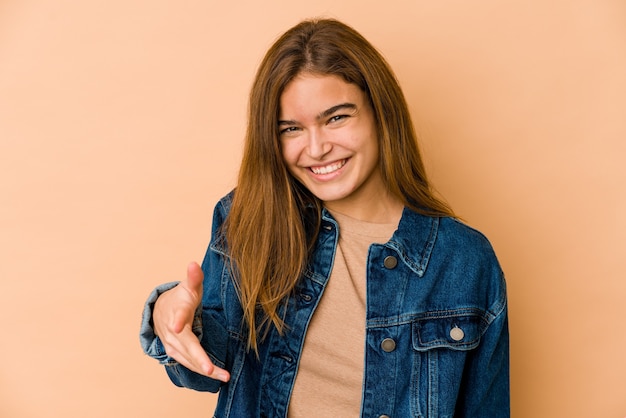 Foto muchacha del adolescente caucásico flaco joven que estira la mano en gesto de saludo.