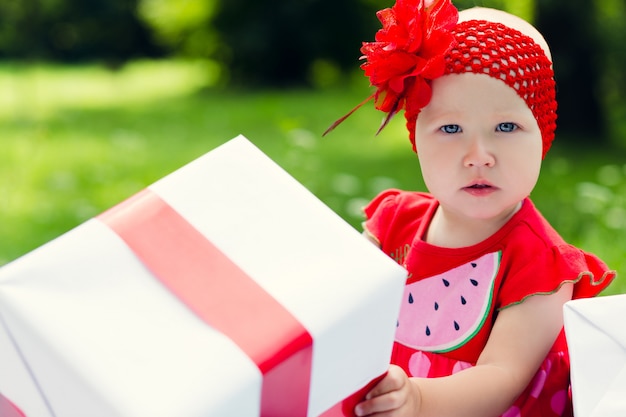 Muchacha alegre del niño con las cajas de regalo coloridas
