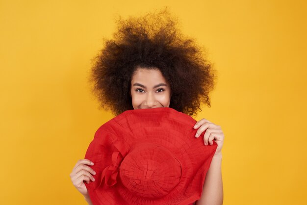 Foto muchacha americana con la presentación del sombrero rojo en amarillo.