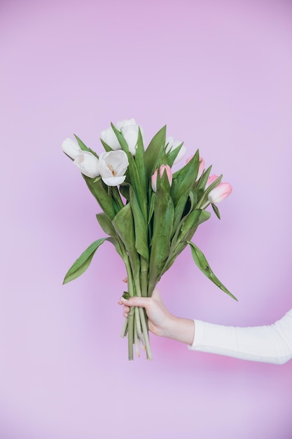 Muchacha de la belleza que sostiene el ramo de flores de los tulipanes de la primavera y que sonríe. Día de San Valentín. Día de la Madre.