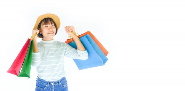 La muchacha bonita del niño da sostener el bolso de compras aislado en el fondo blanco.