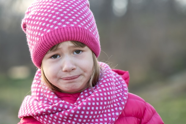 Muchacha bonita del niño en ropa de invierno de punto caliente al aire libre.