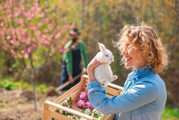 Muchacha bonita que se prepara para la Pascua. Primavera. Mujer y conejo.