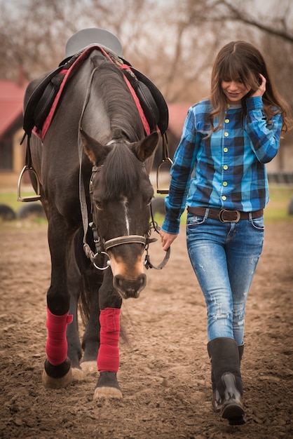 Muchacha con un caballo en día nublado del otoño del rancho onn.