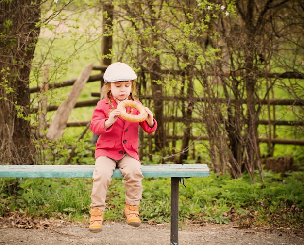 Muchacha divertida con donut al aire libre