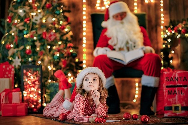 Muchacha divertida en el sombrero de Santa escribe carta a Santa