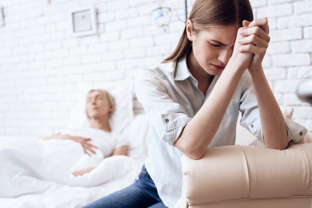 La muchacha está cuidando a la mujer mayor en cama en casa.