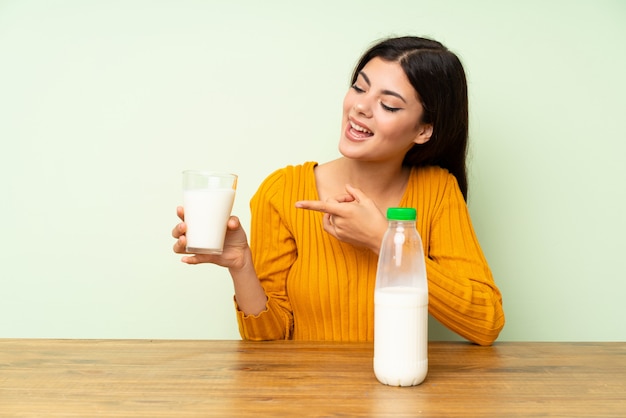 Muchacha feliz del adolescente que desayuna la leche