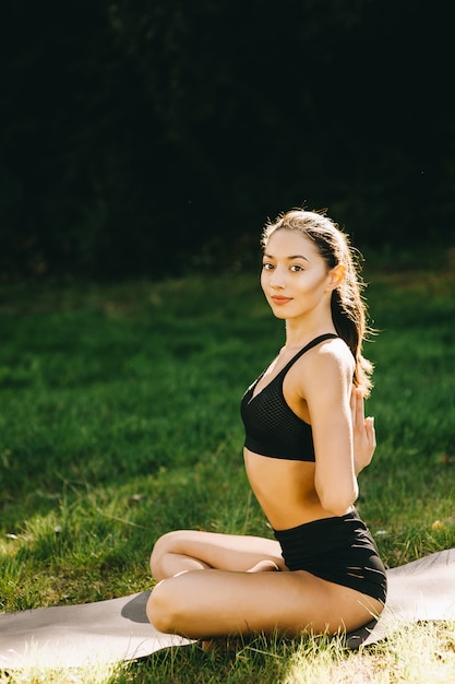 Muchacha hermosa de la aptitud que ejercita en naturaleza en día de verano soleado.