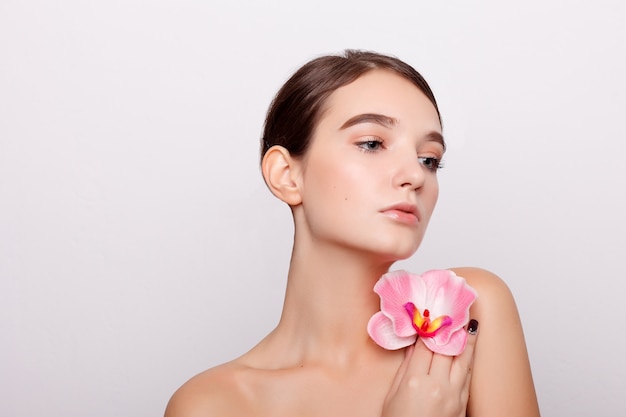 Muchacha hermosa con las flores de la orquídea.