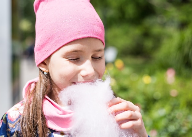 Muchacha hermosa del niño con el pelo largo en la tapa rosa que sonríe al aire libre