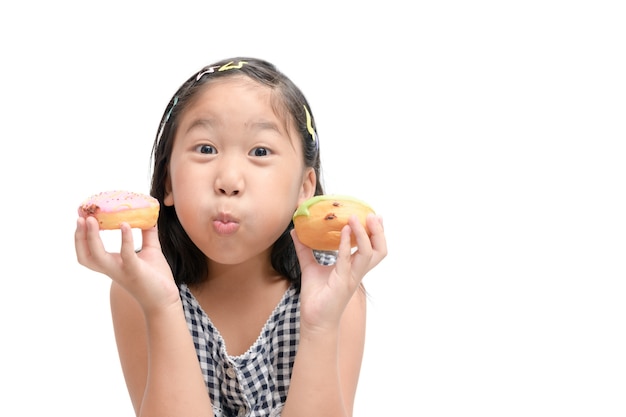 La muchacha linda feliz está comiendo el buñuelo aislado