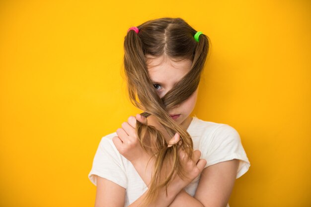 La muchacha linda del niño cierra su cara con su pelo. Período menstrual por primera vez concepto