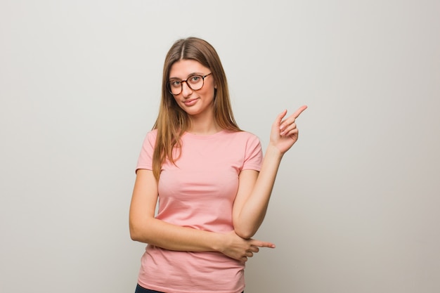 Muchacha natural rusa joven que señala al lado con el dedo