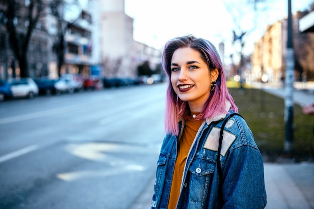 Muchacha con el pelo colorido en la calle de la ciudad.